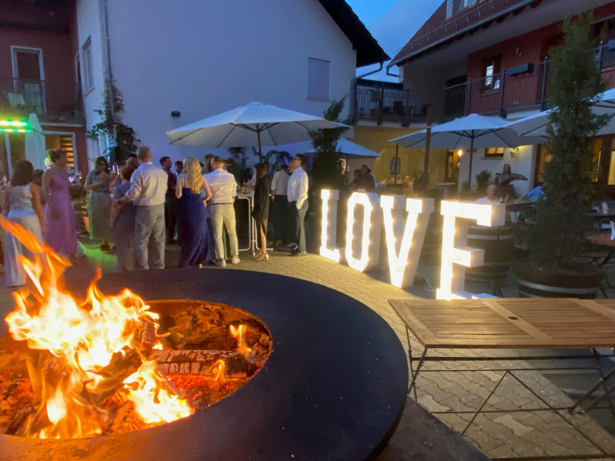 Abendliche Feier mit Feuer und Gästen im Innenhof von Metzler Moments