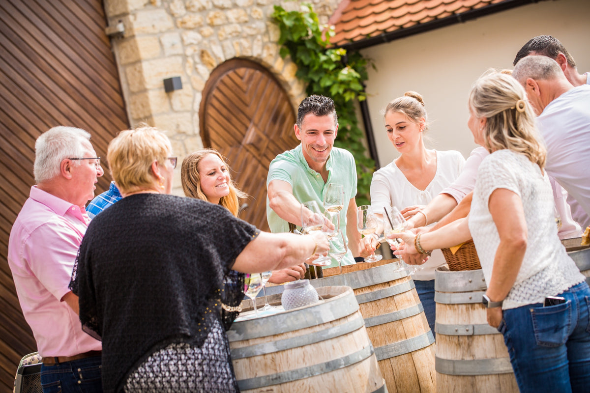 Stefan Metzler schenkt Gästen bei TREFF.WEIN im Innenhof Wein ein