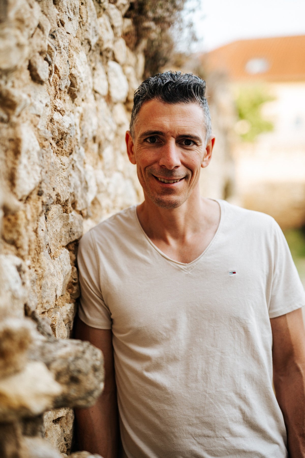 Stefan Metzler vor einer Natursteinwand im Weingut